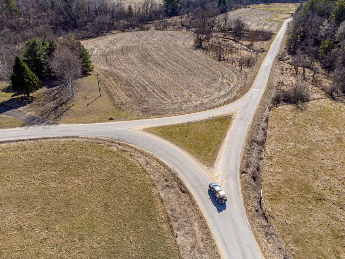 Aerial view of a country road splitting in two between farm fields