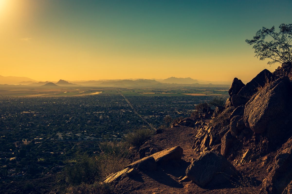 View across the Phoenix valley at sunset from a rocky trail on Camelback Mountain